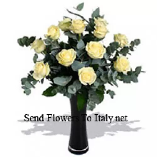 11 roses blanches avec quelques fougères dans un vase